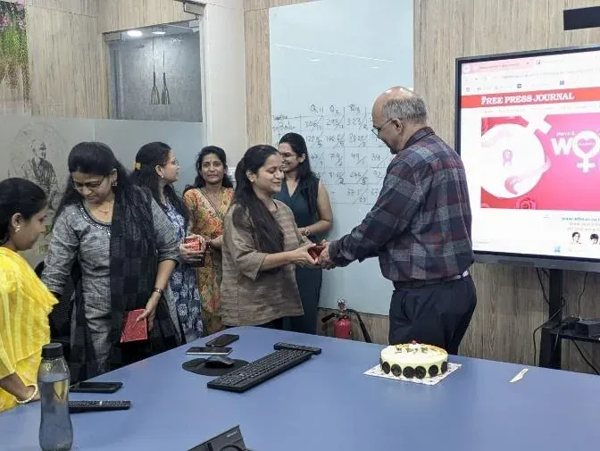Women's Day celebration at Urja-Disha, gift boxes being handed to the women of the team beside the celebration cake