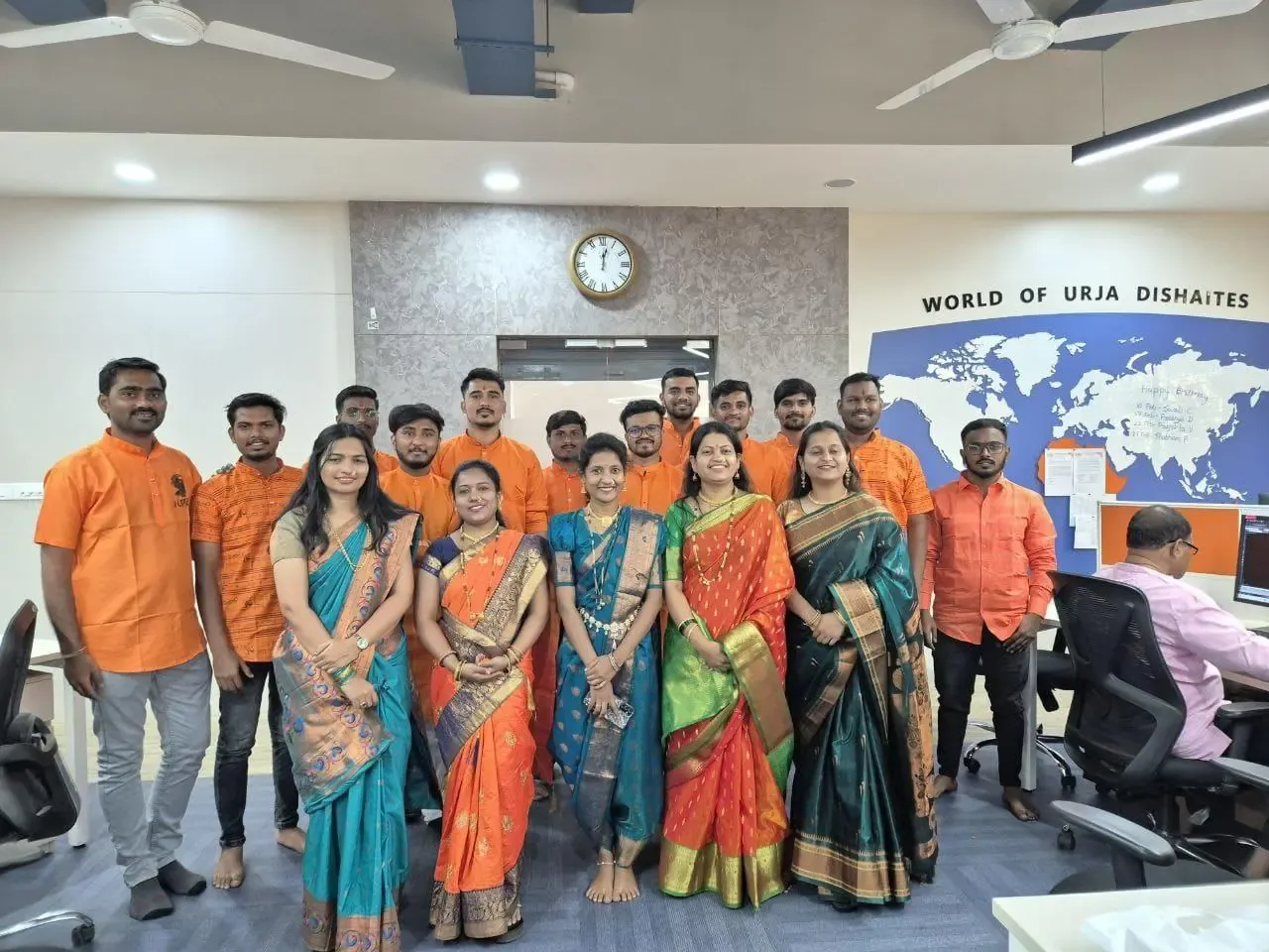 Urja-Disha team in traditional saffron kurtas and sarees for Shivaji Jayanti, in front of the World of Urja Dishaites wall map