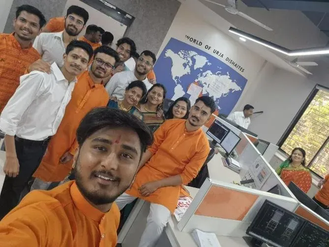 Engineers in saffron kurtas taking a group selfie in the design office on Shivaji Jayanti