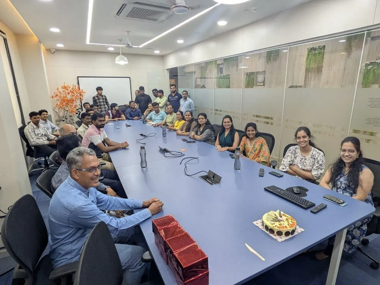 The full Urja-Disha team seated around the long conference table for the Women's Day celebration
