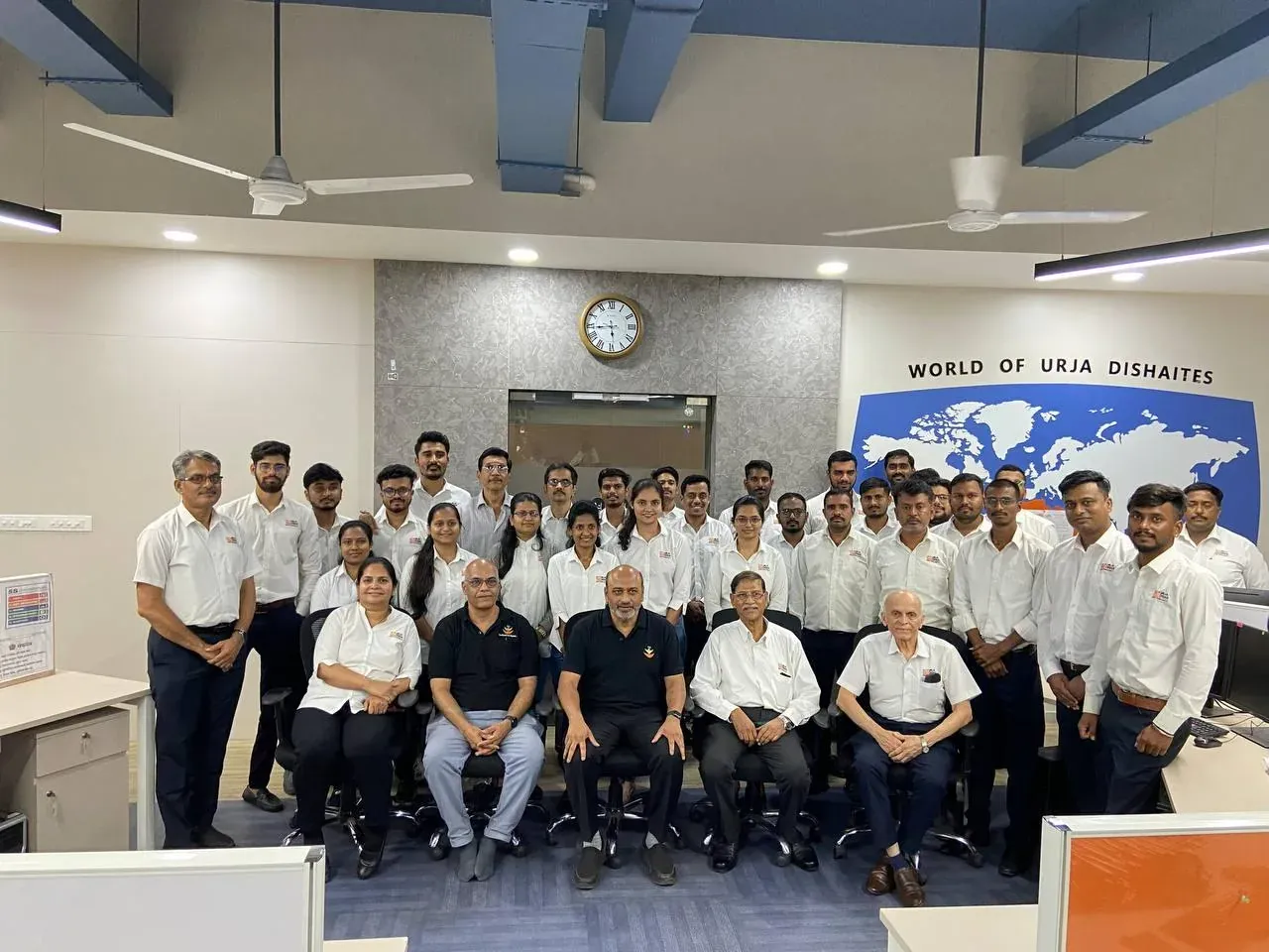 Full Urja-Disha team group photograph in the new open-plan office beneath the World of Urja Dishaites world map