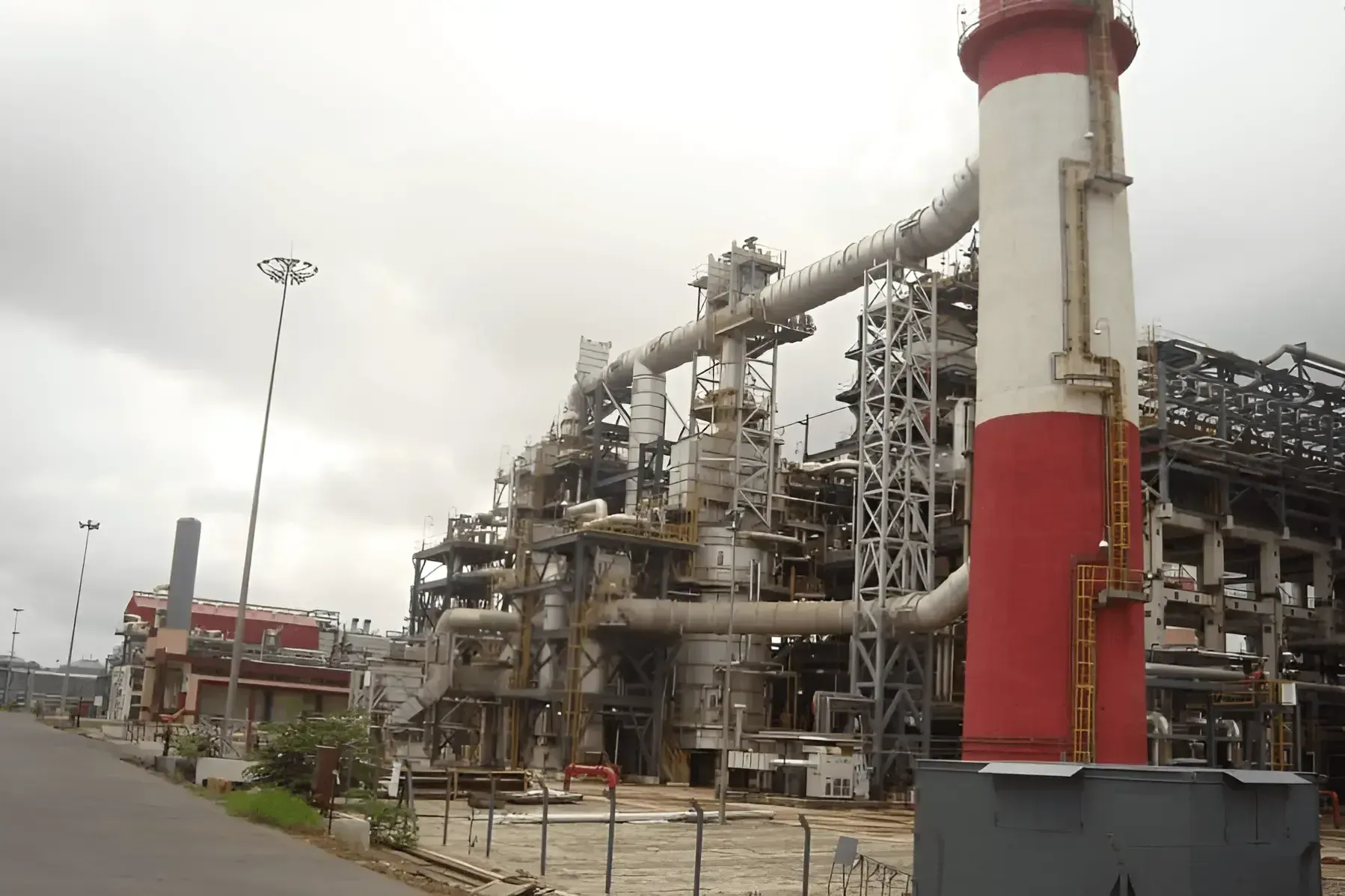 Petrochemical plant with fired heaters, large flue gas ducting and a red and white banded stack