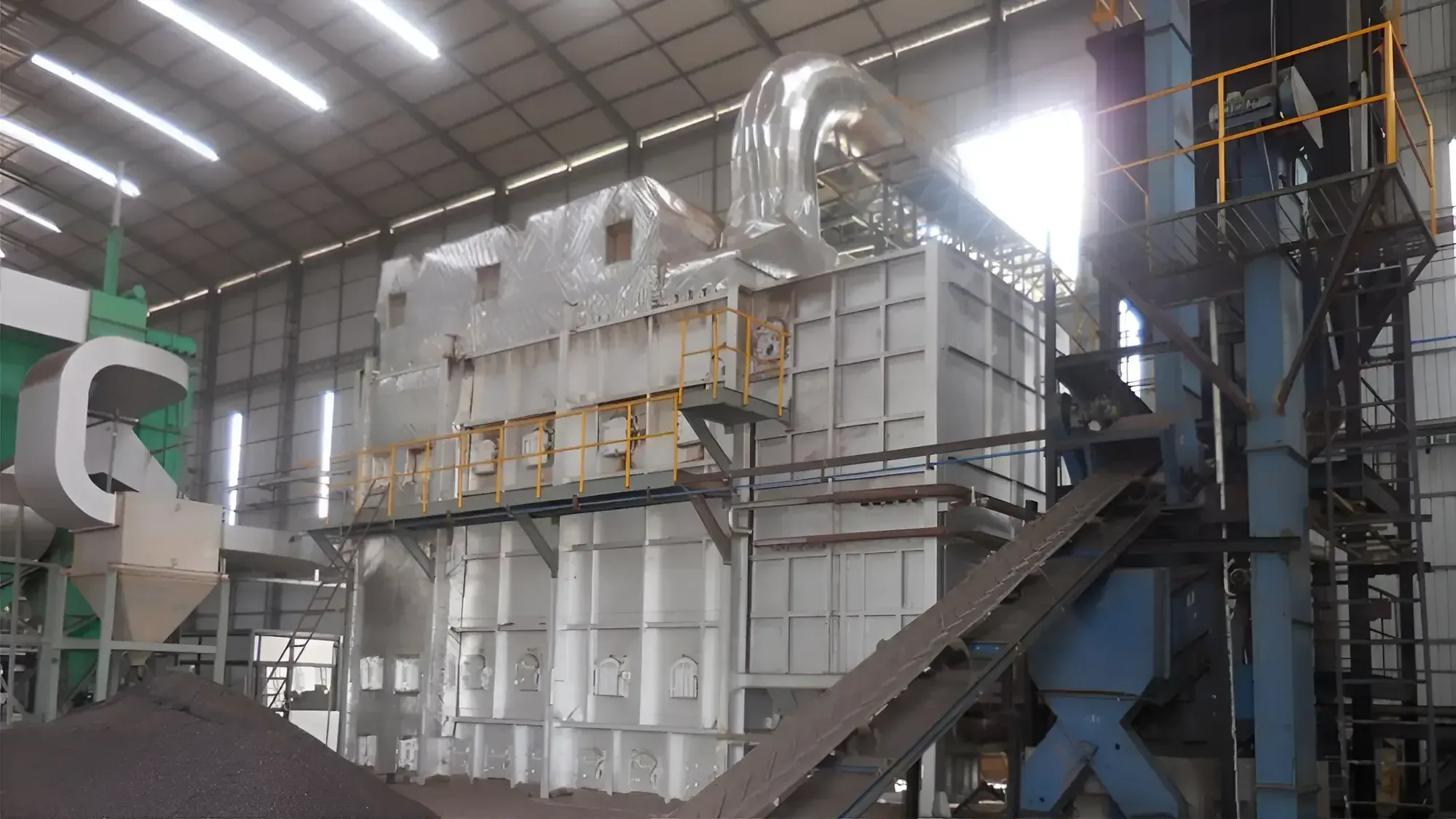 Coal-fired hot air generator with insulated hot air duct and fuel conveyor inside a plant hall